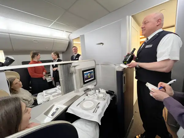 british airways first class crew attending to passenger with personalized service