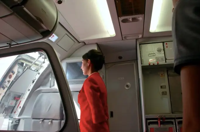 cabin crew standing near cockpit entrance during boarding