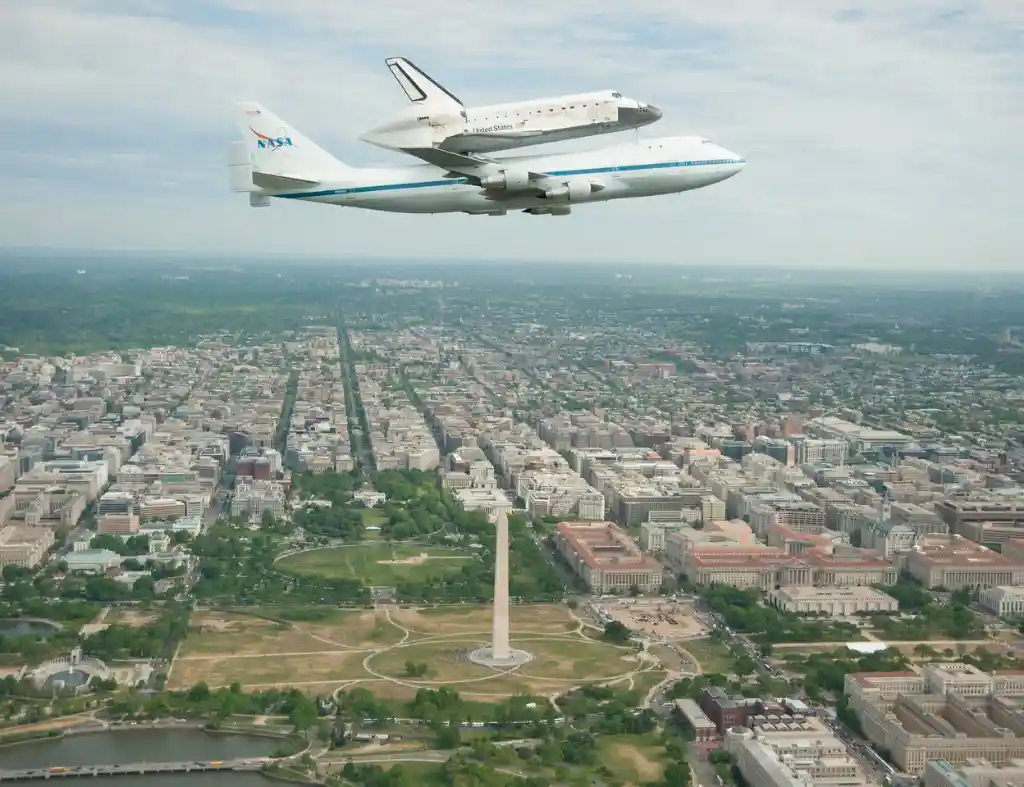 Space Shuttle Discovery atop NASA 905 flying over the National Mall in Washington D.C.