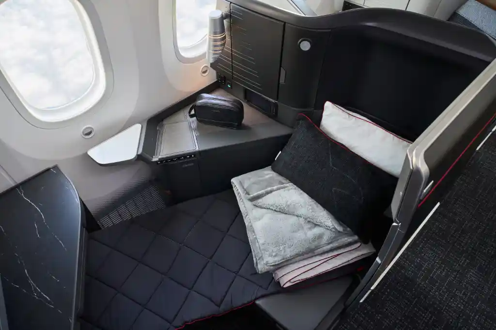 american airlines flagship suite passenger enjoying lie-flat seat with meal service