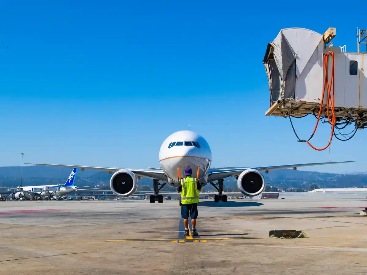 ground crew performing final checks under aircraft wing before pushback