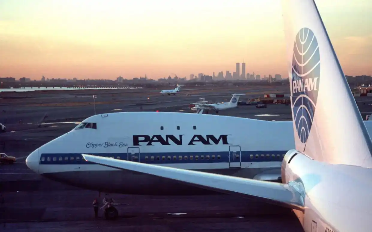 Vintage Pan Am globe logo beside a Boeing 747 at sunset