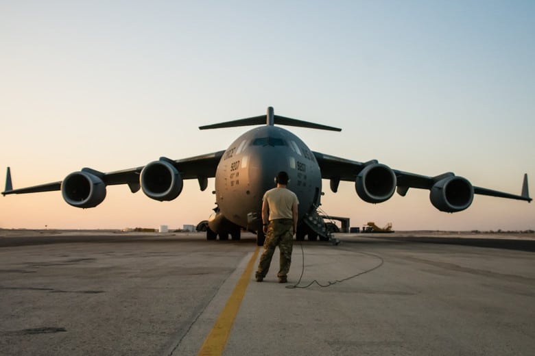 airline pilot in military flight suit reviewing deployment orders inside airport terminal