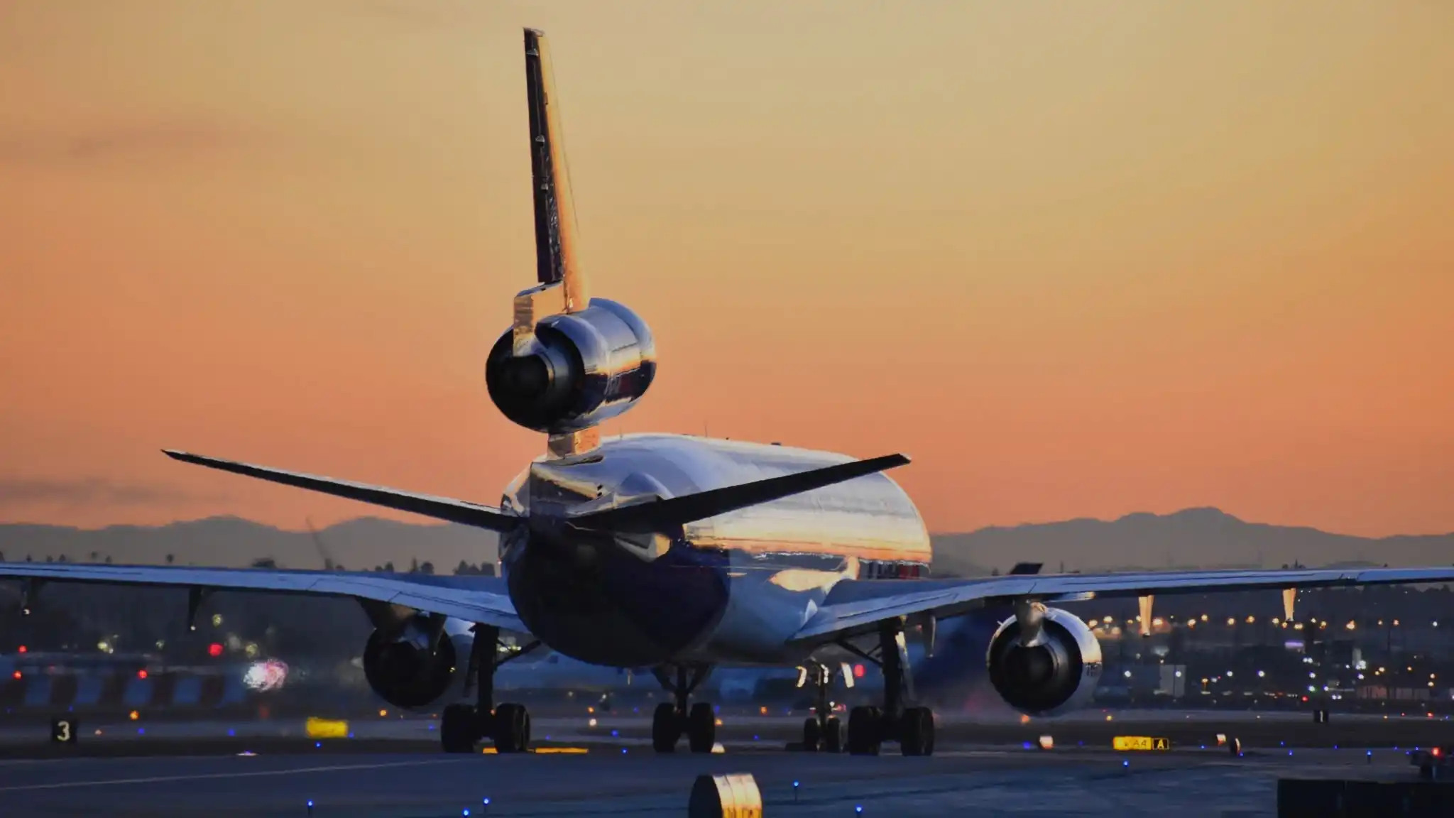 FedEx McDonnell Douglas MD-11F freighter loading cargo containers at night ramp