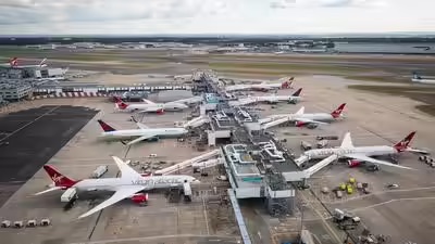 Heathrow runway with multiple commercial aircraft awaiting departure