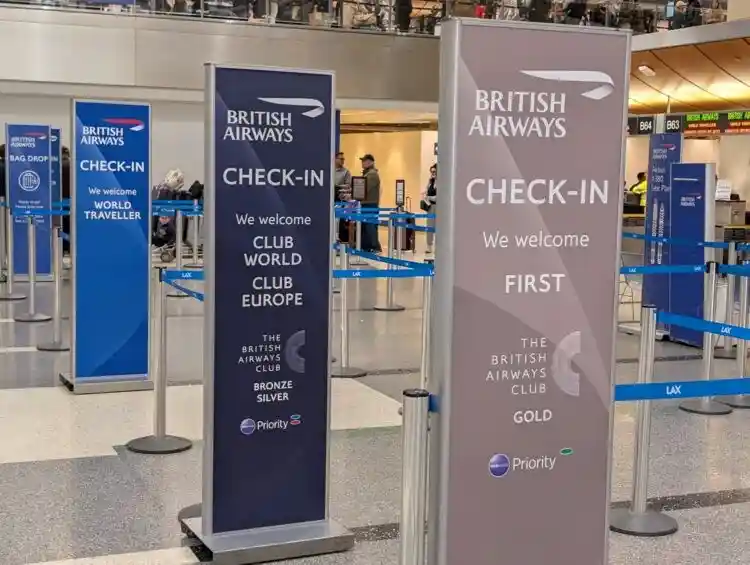 airport check-in counters with oneworld priority signage passengers
