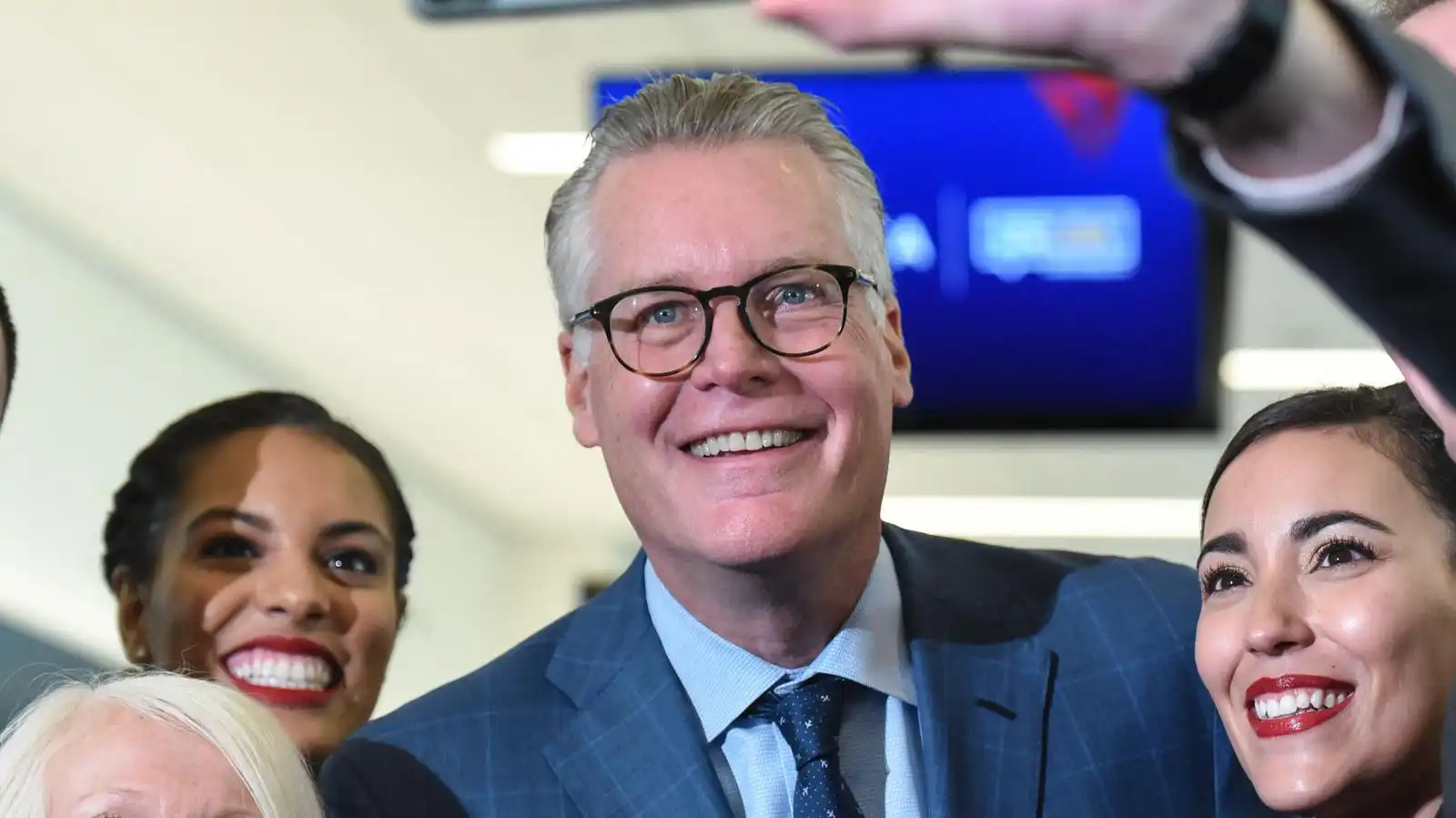 Delta Air Lines CEO Ed Bastian speaking with flight attendants inside a commercial aircraft cabin