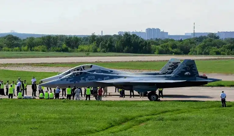 Su-57 Felon parked at Russian airbase with maintenance personnel and fifth-generation fighter markings