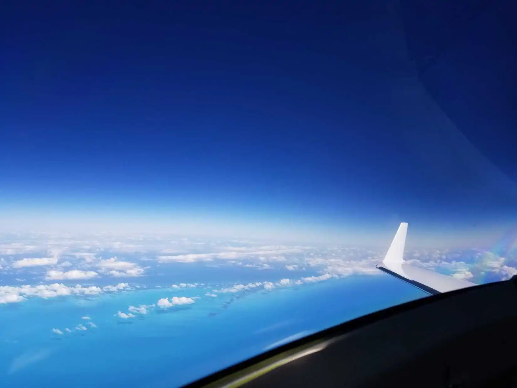 pilot view from 51,000 feet showing dark indigo sky distant horizon and Earth below