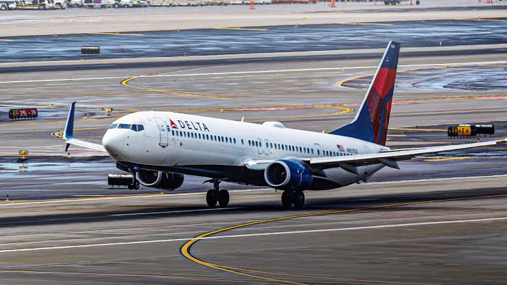 Boeing 737-900ER main landing gear and aft fuselage above runway surface during rotation